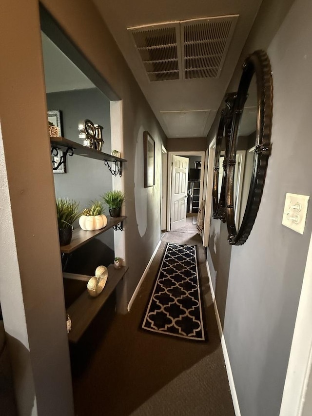 hallway featuring baseboards and visible vents