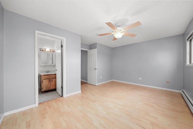 9960 Franchesca Ct Unit 3A, Orland Park, IL 60462 - unfurnished bedroom featuring baseboard heating, a textured ceiling, baseboards, light wood finished floors, and a sink