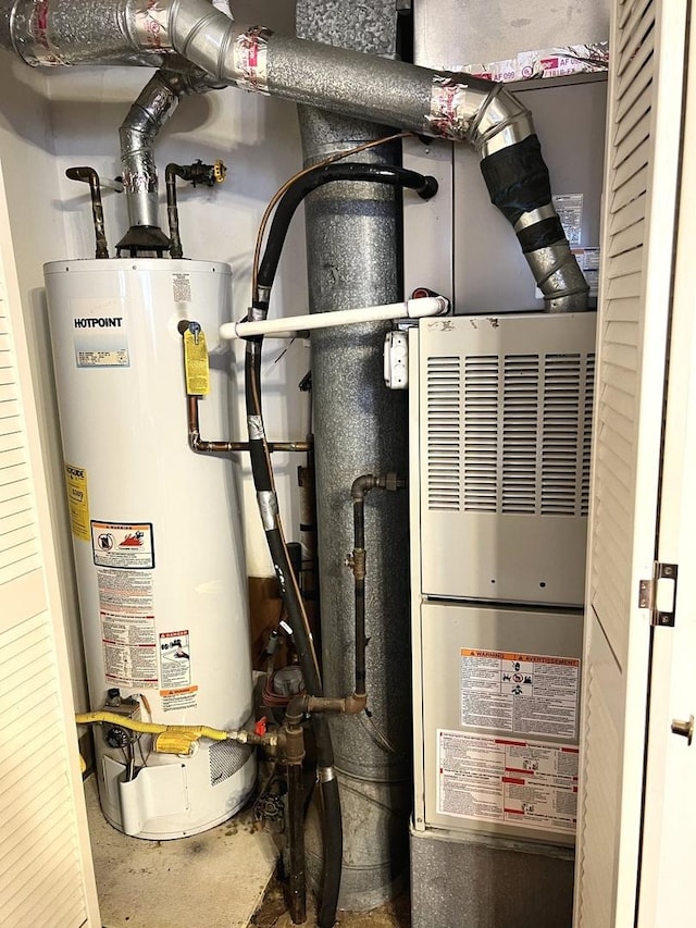 utility room featuring water heater and heating unit