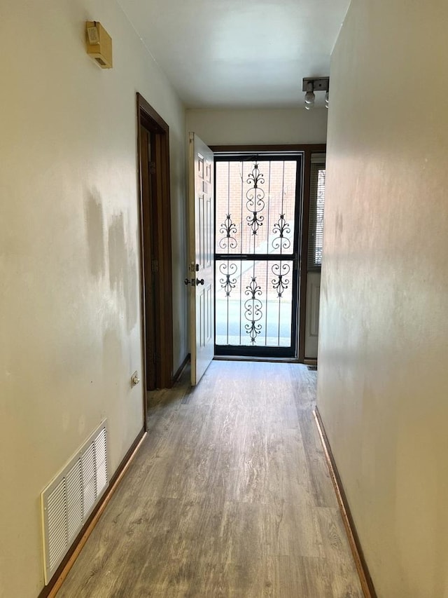 corridor featuring wood finished floors and baseboards