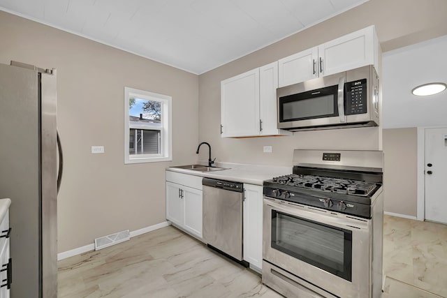622 E Joliet St, Ottawa, IL 61350 - kitchen featuring appliances with stainless steel finishes, light marble finish flooring, a sink, white cabinetry, and baseboards