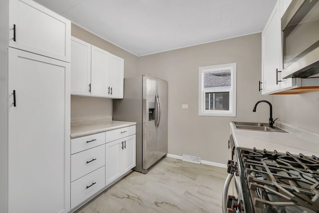 622 E Joliet St, Ottawa, IL 61350 - kitchen featuring a sink, appliances with stainless steel finishes, light marble finish floors, white cabinets, and crown molding