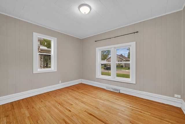 622 E Joliet St, Ottawa, IL 61350 - unfurnished room with plenty of natural light, crown molding, light wood-style floors, baseboards, and wooden walls
