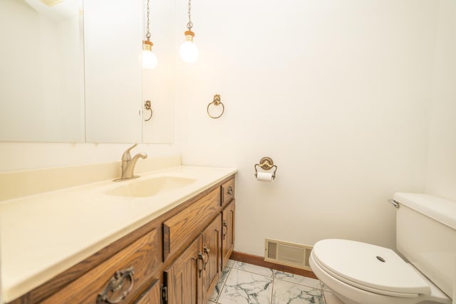 bathroom featuring toilet, marble look tile flooring, vanity, and baseboards