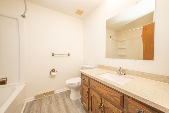 bathroom featuring wood finished floors, toilet, vanity, and baseboards