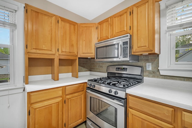 kitchen with light countertops, appliances with stainless steel finishes, and backsplash
