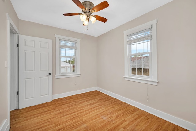 unfurnished room featuring baseboards, a wealth of natural light, ceiling fan, and light wood-type flooring