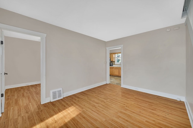 unfurnished room with light wood-style flooring, baseboards, and visible vents