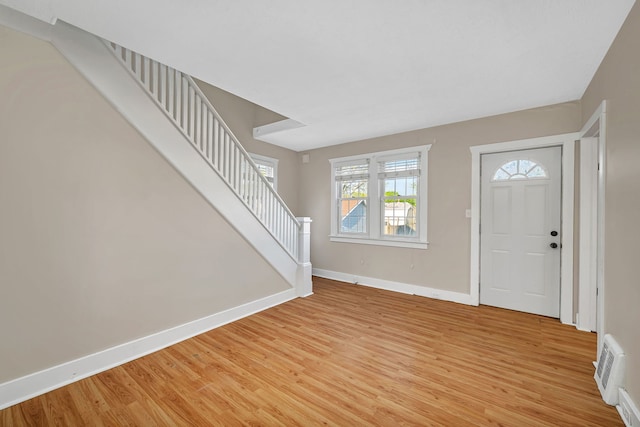 foyer entrance with stairs, baseboards, visible vents, and light wood-style floors