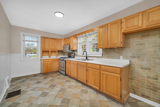 kitchen featuring a sink, a healthy amount of sunlight, visible vents, light countertops, and appliances with stainless steel finishes