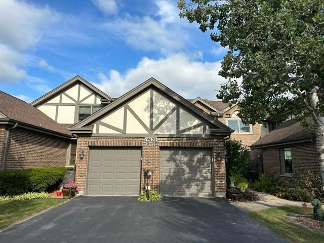 14609 Morningside Rd, Orland Park, IL 60462 - english style home with asphalt driveway, brick siding, an attached garage, and stucco siding