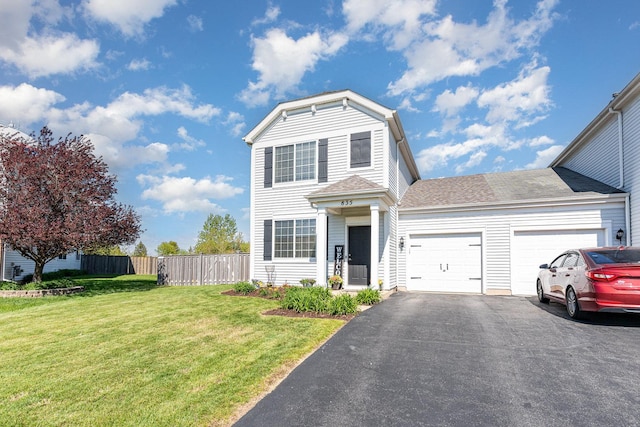traditional home featuring a garage, driveway, and roof with shingles