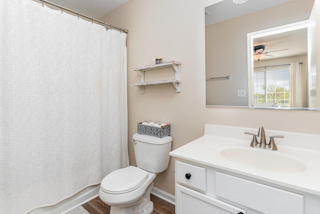 bathroom featuring toilet, wood finished floors, vanity, and baseboards