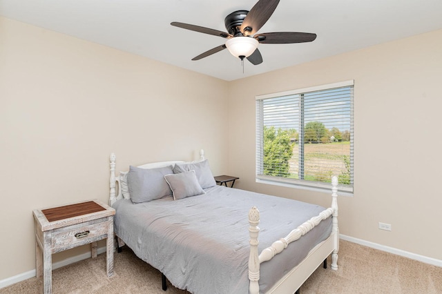 bedroom with light carpet, baseboards, and a ceiling fan