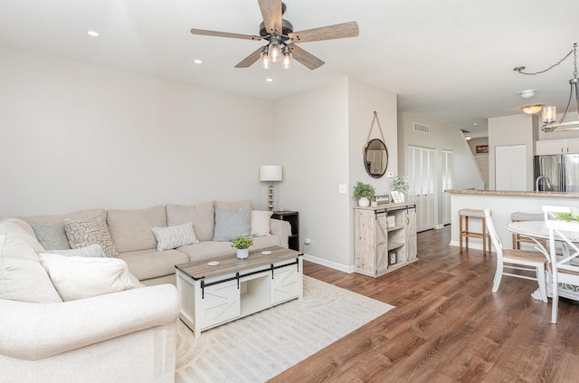 living room featuring wood finished floors, ceiling fan, baseboards, and recessed lighting