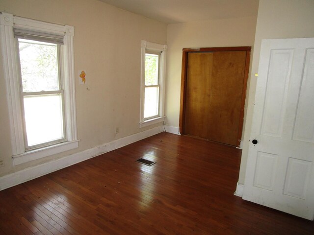 8742 S Racine Ave, Chicago, IL 60620 - unfurnished bedroom with hardwood / wood-style floors, multiple windows, baseboards, and a closet