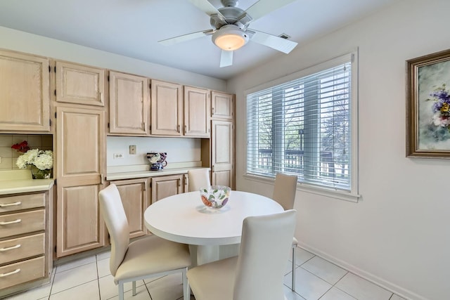 dining space with a ceiling fan, light tile patterned floors, and baseboards