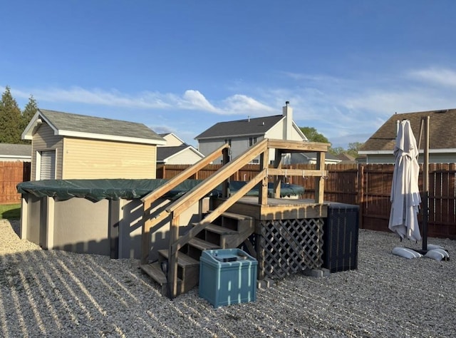 exterior space with an outbuilding, a fenced in pool, a fenced backyard, and stairs
