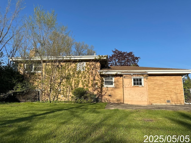 back of house with a yard and brick siding