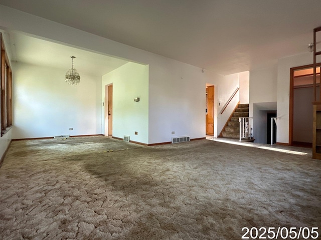 unfurnished living room with carpet floors, a notable chandelier, visible vents, baseboards, and stairs
