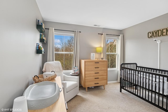 carpeted bedroom featuring a crib, multiple windows, and baseboards