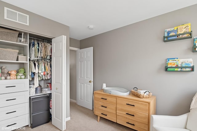 bedroom featuring light carpet, refrigerator, a closet, and baseboards