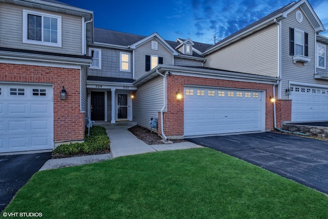 view of front of house featuring asphalt driveway, a garage, brick siding, and a front lawn