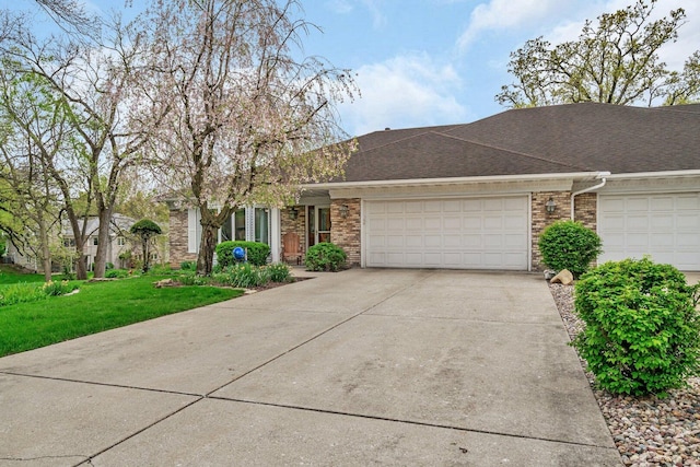 view of front of property featuring a garage, driveway, brick siding, a front yard, and roof with shingles