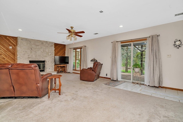 carpeted living room with plenty of natural light, a stone fireplace, ceiling fan, baseboards, and recessed lighting