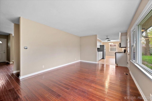 16 Circle Dr E, Montgomery, IL 60538 - unfurnished living room featuring a healthy amount of sunlight, visible vents, and wood finished floors