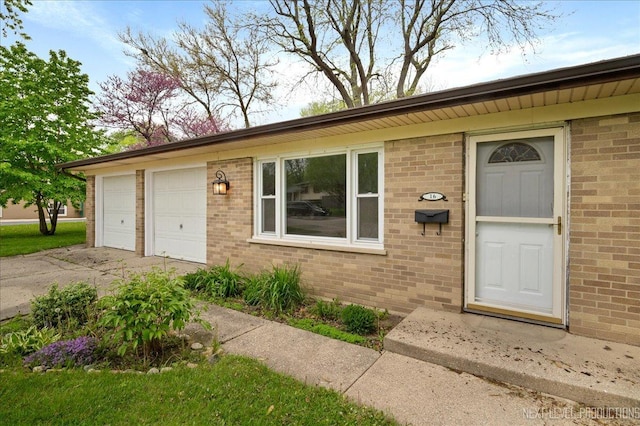 16 Circle Dr E, Montgomery, IL 60538 - doorway to property with concrete driveway, brick siding, and an attached garage