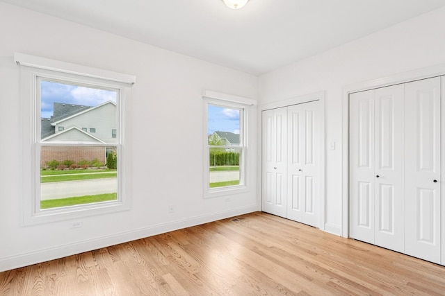 9014 Gloucester Rd, Woodridge, IL 60517 - unfurnished bedroom with two closets, light wood-type flooring, and baseboards