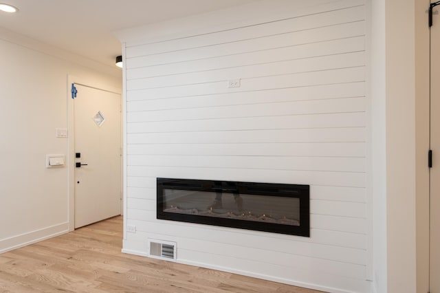 room details with wood finished floors, visible vents, baseboards, a large fireplace, and recessed lighting