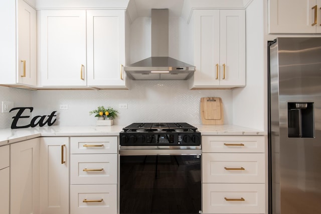 kitchen featuring stainless steel refrigerator with ice dispenser, black range with gas stovetop, wall chimney exhaust hood, white cabinetry, and decorative backsplash