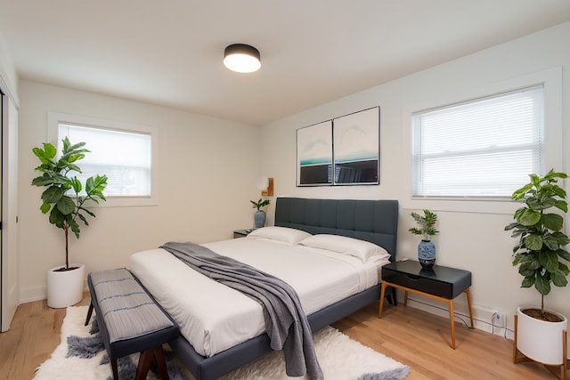 bedroom with baseboards and light wood-style flooring