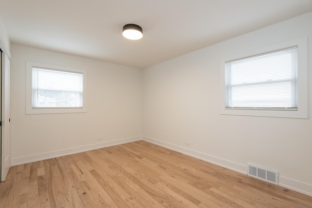 spare room featuring visible vents, light wood-style flooring, and baseboards