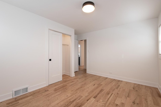 unfurnished bedroom with light wood finished floors, baseboards, a closet, and visible vents