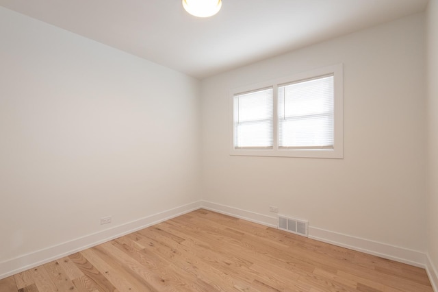 unfurnished room with baseboards, visible vents, and light wood-style floors