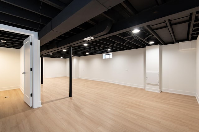 basement featuring baseboards and wood finished floors