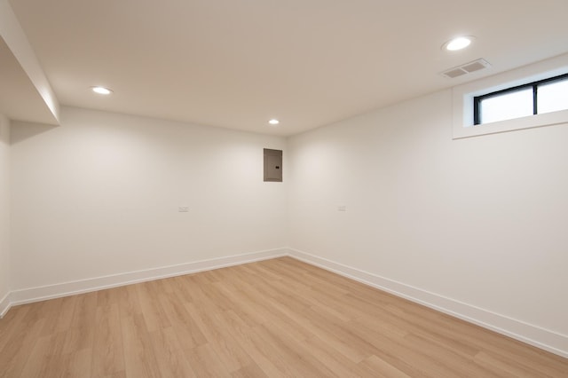 basement with electric panel, visible vents, baseboards, light wood-style floors, and recessed lighting