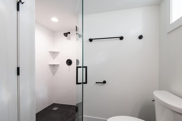 bathroom featuring toilet and a shower stall