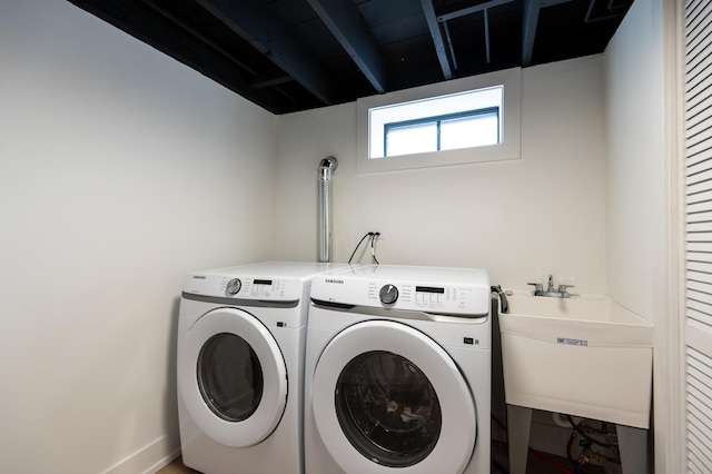 washroom with washer and dryer and a sink
