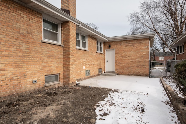 back of house with fence, a patio area, brick siding, and a chimney