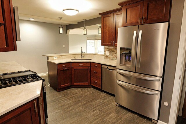 10145 Lawrence Ct, Oak Lawn, IL 60453 - kitchen featuring pendant lighting, a sink, a peninsula, tasteful backsplash, and appliances with stainless steel finishes