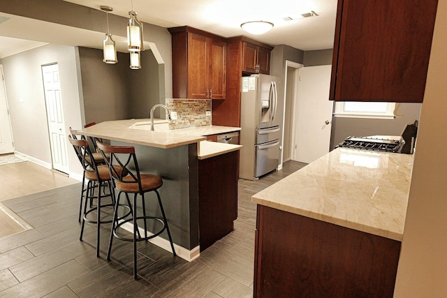 10145 Lawrence Ct, Oak Lawn, IL 60453 - kitchen featuring a peninsula, a kitchen bar, stainless steel refrigerator with ice dispenser, dark wood-style flooring, and decorative backsplash
