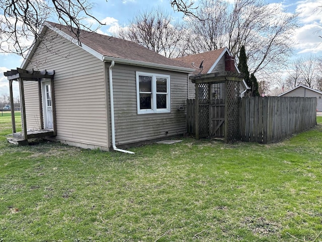 view of side of home with roof with shingles