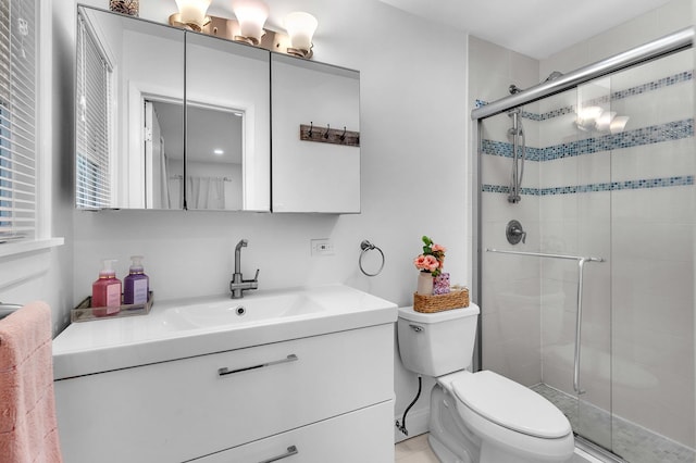 full bath with toilet, vanity, and a stall shower