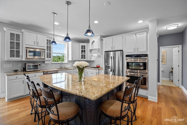 9692 Baumgartner St, Huntley, IL 60142 - kitchen featuring appliances with stainless steel finishes, a sink, white cabinetry, a kitchen bar, and recessed lighting