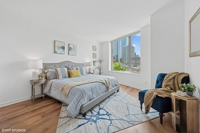 bedroom with wood finished floors and baseboards