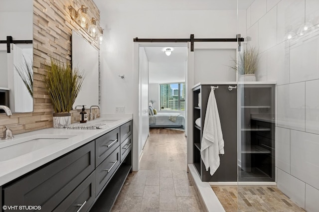 full bath featuring connected bathroom, double vanity, and backsplash